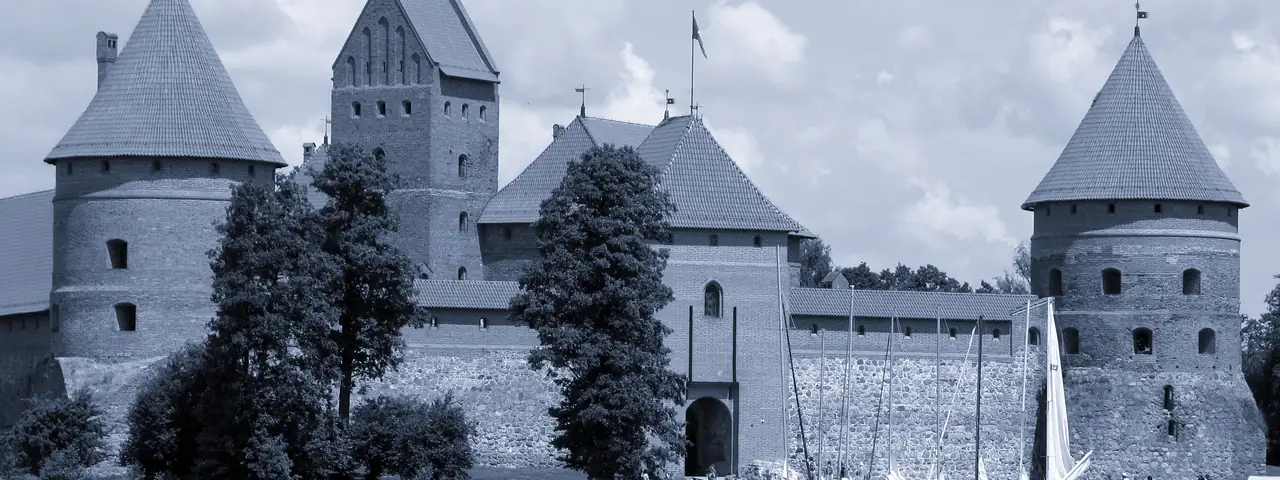 Trakų salos pilis prie ežero: raudonų plytų mūras, kampiniai bokštai su čerpių stogais